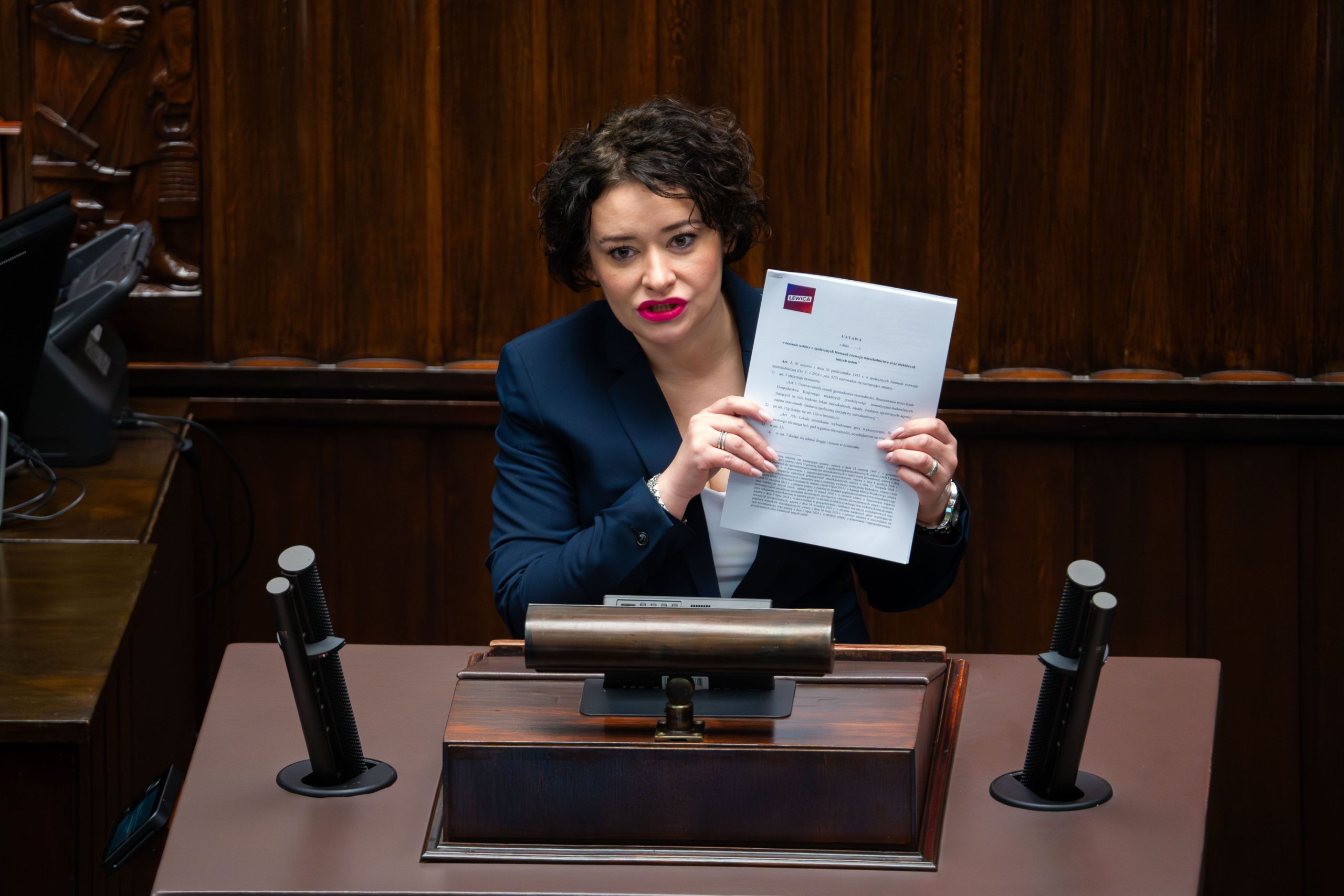 Posłanka Lewicy przemawia na mównicy sejmowej, prezentując rządowy projekt ustawy o budownictwie społecznym jako projekt poselski.